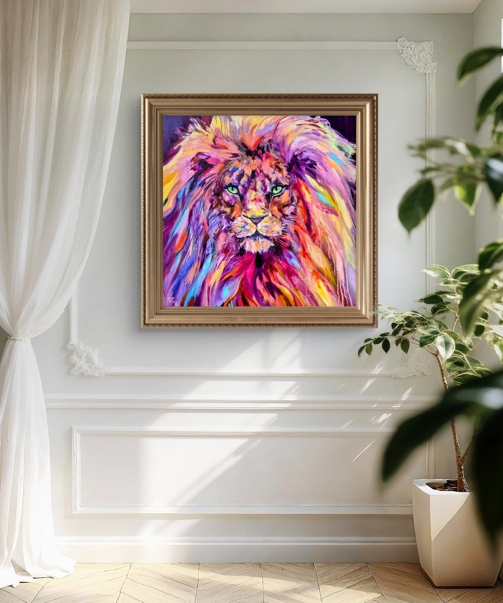 Colorful lion painting in a gold frame on a white wall with a plant to the right.