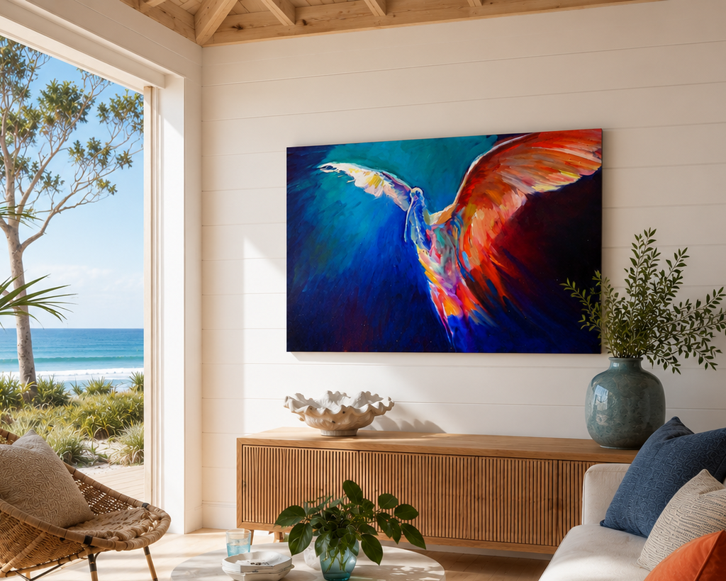 Living room with a colorful abstract painting of a bird on the wall, large windows showing a beach view, and decorative items.