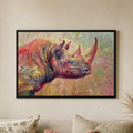 A framed colorful painting of a rhinoceros hanging on a beige wall above a sofa with pillows.