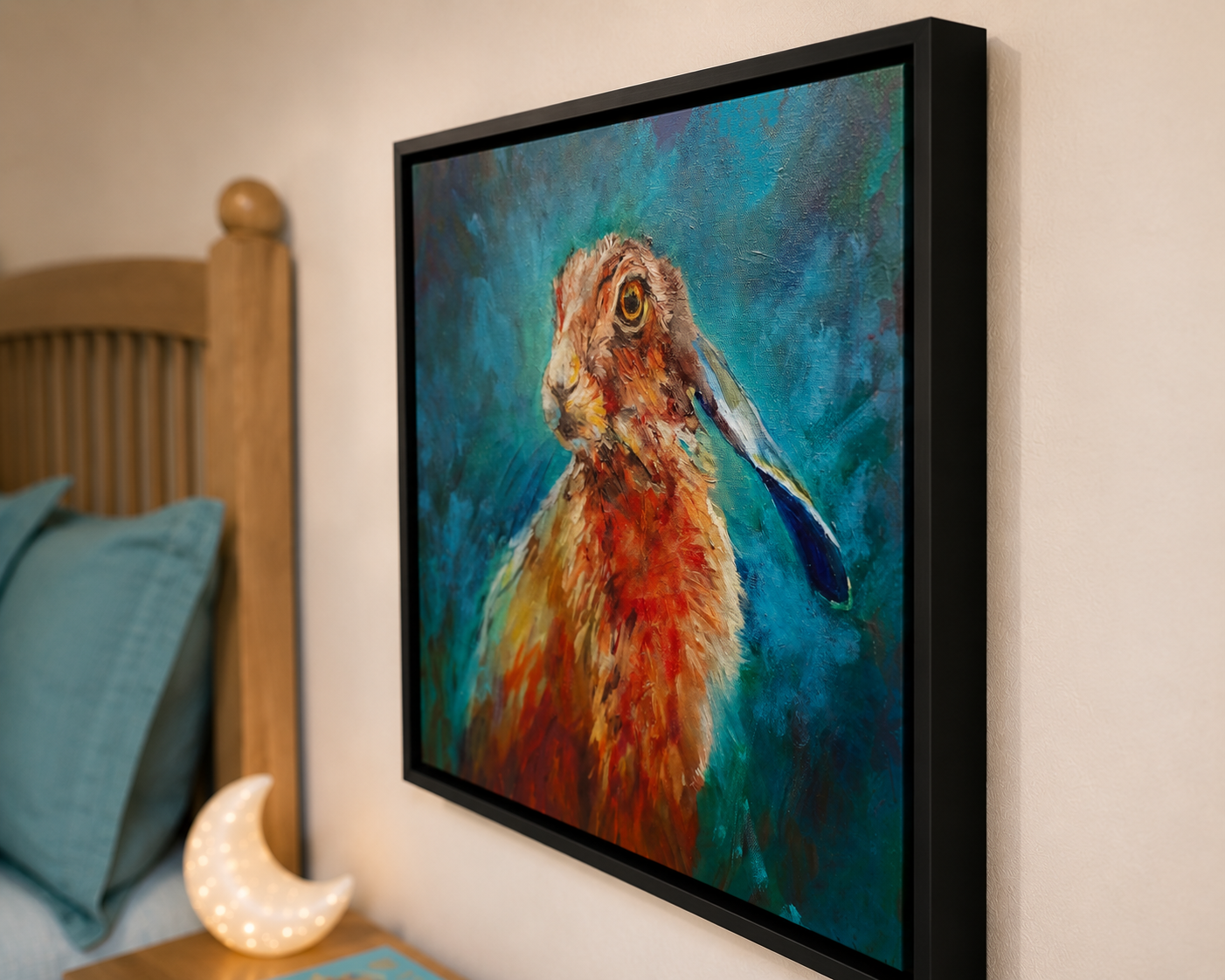 Framed painting of a hare on a wall next to a bed with blue pillows.