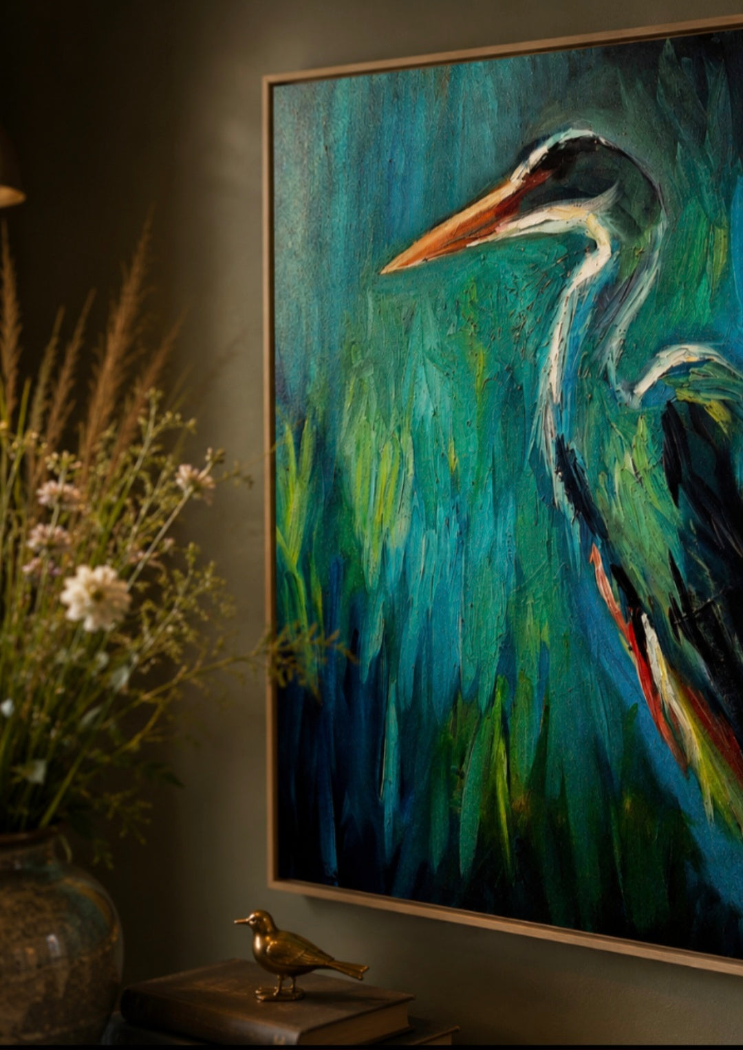 Framed painting of a heron on a wall with decorative elements.
