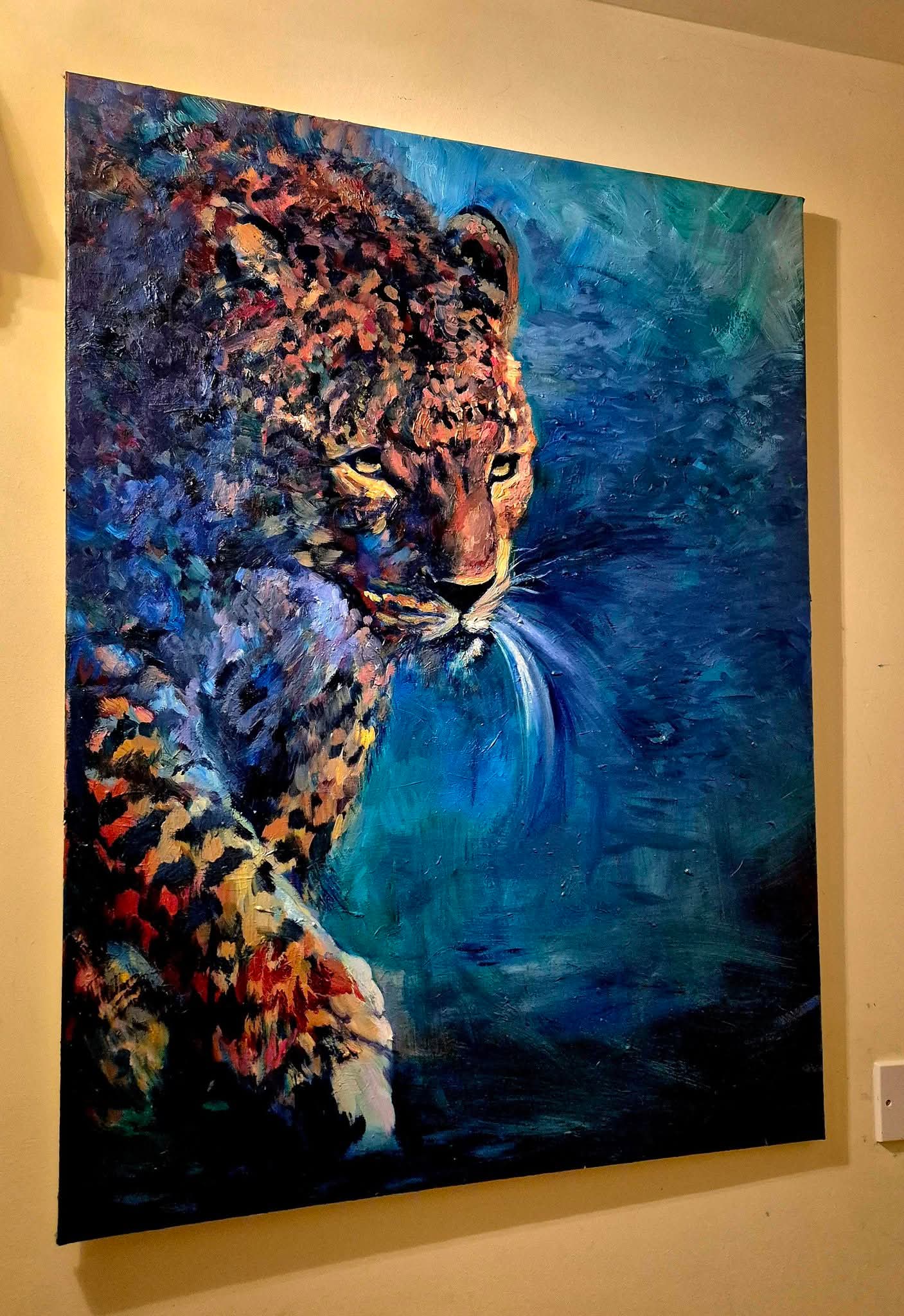 Colorful painting of a leopard on a blue and black background