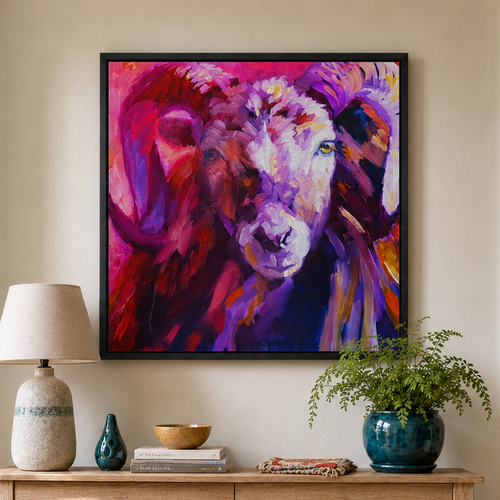 A colorful framed wall art print depicting a stylized ram head in vivid purple, pink, and red tones, displayed in a real home interior above a wooden console table.