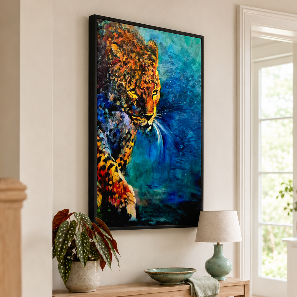 A framed vertical canvas art print depicting a colorful leopard against a blue background, displayed on a beige wall above a wooden console table in a bright, modern room.