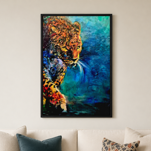 A framed vertical canvas print of a colorful leopard painting hanging on a beige wall above a cream-colored sofa with decorative pillows.