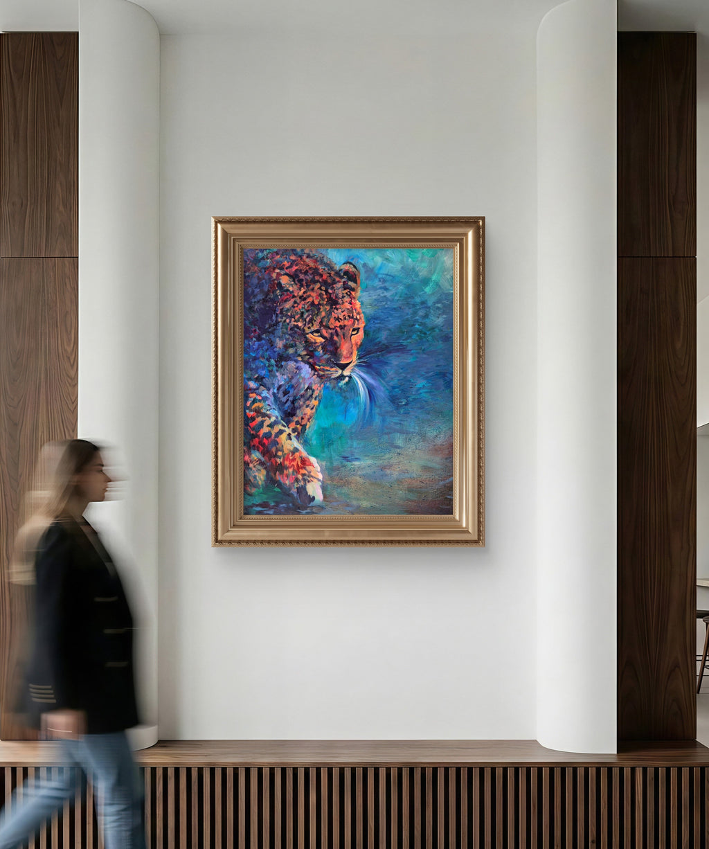 Woman walking past a wall with a colorful painting of a leopard in a gold frame.