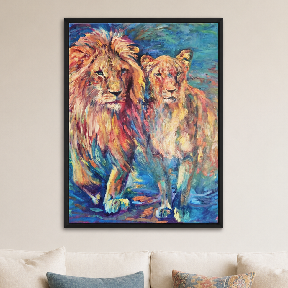 A framed colorful painting of two lions hanging on a beige wall above a white sofa with pillows.