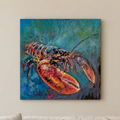 A square canvas wall art print depicting a lobster in a textured blue and green underwater scene, displayed on a beige wall above a light-colored sofa with a pillow.