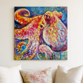 A colorful canvas painting of an octopus hanging on a light beige wall above a sofa with cream and patterned pillows.