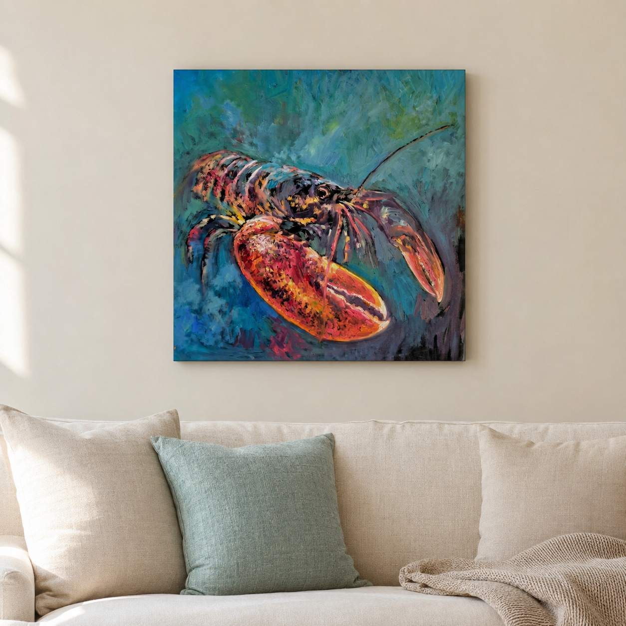 A square canvas wall art print depicting a lobster in vibrant blue and orange tones, displayed on a beige wall above a light-colored sofa with pillows.