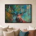 A framed colorful painting of a deer with large antlers hanging on a beige wall above a cream sofa with decorative pillows.