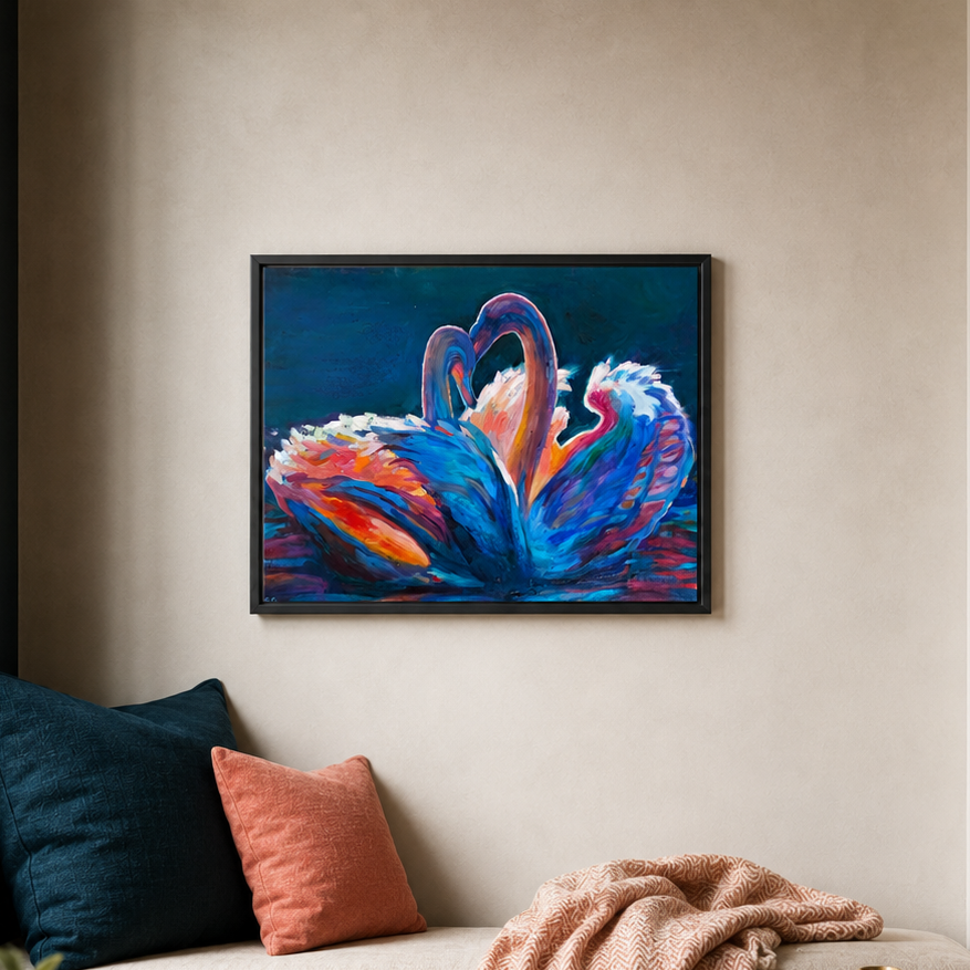 A framed abstract painting of two swans forming a heart shape, displayed on a beige wall above a couch with pillows and a blanket.